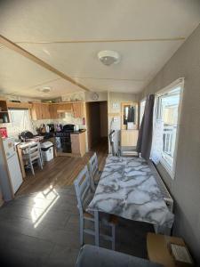 a room with a table and chairs in a kitchen at Accessible and dog friendly caravan in Ingoldmells