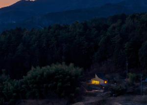a house in the middle of a forest at night at OKANiWA 丘庭 in Nagiso +38 photos