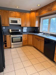 a kitchen with wooden cabinets and stainless steel appliances at Get Away Casino in Bensalem