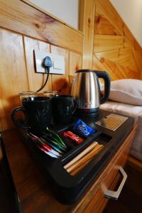a tray with three bowls and a tea kettle on a table at Jawai Himalayan Cottage in Vashisht