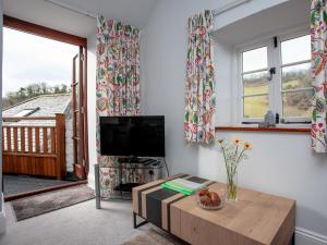a living room with a tv and a table at Tuckenhay, 4 Castle Cottage- Fcn in Ashsprington