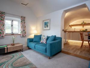 a living room with a blue couch and a table at Tuckenhay, 4 Castle Cottage- Fcn in Ashsprington