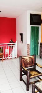 a room with a chair and a red wall at Edotel Tebe Syariah in Rampal