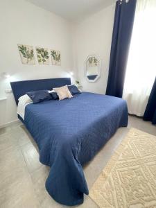 a bedroom with a blue bed with a blue blanket at Tea House Alghero in Alghero