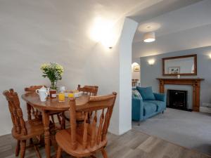 a dining room with a table and a blue couch at Tuckenhay, 4 Castle Cottage- Fcn in Ashsprington