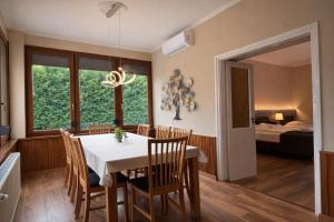 a dining room with a table and chairs and a bedroom at Honti Apartmanház in Visegrád