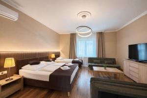 a hotel room with a bed and a flat screen tv at Honti Apartmanház in Visegrád