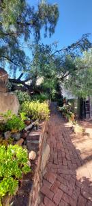 a garden with a brick walkway with plants and trees at Karoo-Koppie in Colesberg