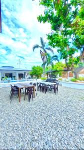 a group of picnic tables and benches on a beach at Villa de Flynn Private Resort in Bauang