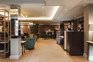 a lobby of a hotel with people sitting at tables at The Malone Hotel in Belfast