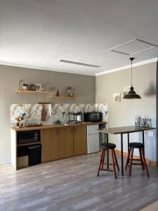 a kitchen with a table and two bar stools at StayComfy on Jasmin in Oakdale