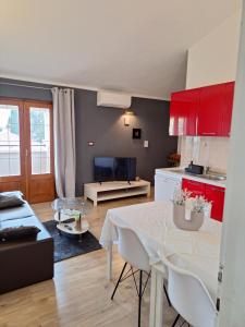 a kitchen and living room with a white table and chairs at Apartments and Rooms Lorena 236 in Rovinj