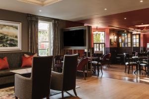 a restaurant with a bar with tables and chairs at The Malone Hotel in Belfast