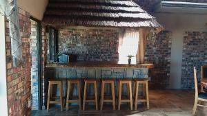 a kitchen with a bar with a brick wall at Dolphin Villa in Gqeberha