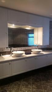 a bathroom counter with three sinks and a mirror at Dolphin Villa in Gqeberha +23 photos