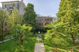 a garden with palm trees in front of a building at Cinqueteste Luxury Home in Venice