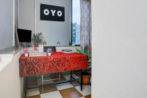 a table in a room with a red table cloth at Hotel O Aqua Comforts in Yelahanka