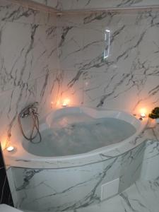 a white marble bathroom with a bath tub at Studio apartman Aria in Đakovo