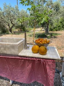 a table with a bowl of oranges and a bowl of fruit at Eudaimonia Wooden Suites Nafplio Kandia in Kandia +90 photos