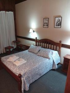 a bedroom with a bed and two tables in it at Altos de Soberana in El Calafate