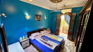 a blue bedroom with a bed with shoes on it at Villa Barba Luxor in Luxor +81 photos