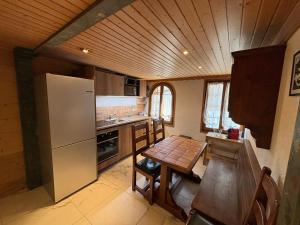 a small kitchen with a table and a refrigerator at Le Vieux Chalet in Gstaad