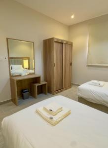 a room with two beds and a mirror at Alturya in Al-ʿUla