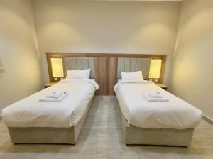 two beds sitting next to each other in a room at Alturya in Al-ʿUla