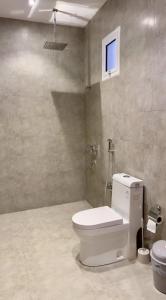 a bathroom with a white toilet in a room at Alturya in Al-ʿUla