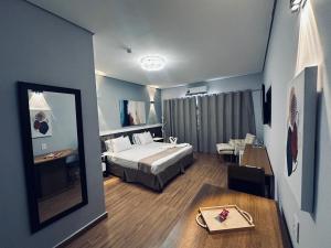 a hotel room with a bed and a table at Charles Hotel in Pôrto Ferreira