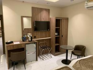 a room with a tv and a table and chairs at منازل الثقة in An Nikāshah +134 photos