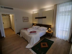 a bedroom with a large bed and a large window at Hotel Pacsirta in Sovata +46 photos