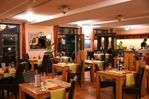 a restaurant with tables and chairs in a room at Waldhotel Rheinbach in Rheinbach