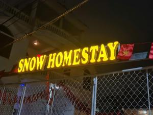 a snowy homesteadasy sign on top of a fence at Snow Homestay in Ninh Binh