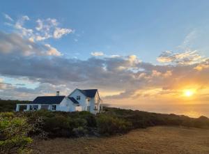 a white house on the beach with the sunset at Guests at 32 Nautilus Bay in Dana Bay +40 photos