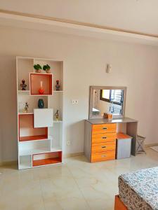 a room with a bedroom with a dresser and a mirror at Résidence Atlantis F2 avec balcon vue dégagée in Dakar