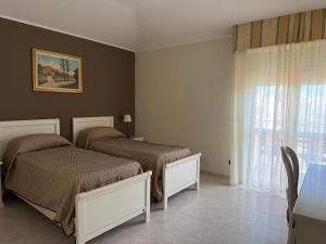 a bedroom with two beds and a window at Hotel San Marco in Alghero +35 photos