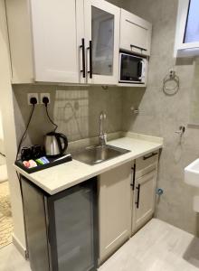 a small kitchen with a sink and a microwave at Alturya in Al-ʿUla