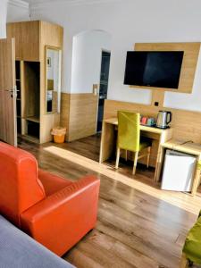 a living room with a couch and a table and a television at DAD Vogelweiderhof Rooms in Salzburg