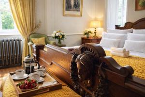 a bedroom with a bed with a tray of fruit on it at Chateau d'Isigny - Normandie - Country House in Isigny-le-Buat