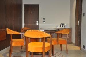 a kitchen with wooden chairs and a table with a counter at Pahadi Convention in Rourkela