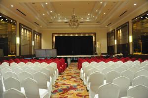 a conference room with white chairs and a screen at Pahadi Convention in Rourkela +58 photos