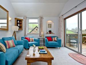 a living room with blue couches and a table at Tuckenhay, Millers Thumb - Hhv in Ashsprington +33 photos