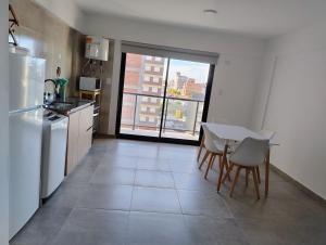 a kitchen with a table and a table and chairs at Apartment 1 block from the sea in Mar de Ajó
