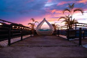 a hammock on the beach with a sunset in the background at Serenity Busay Room 8 in Cebu City