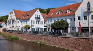 a row of white buildings next to a river at Palazzo Moni - Modernes Studio in der Nähe der Therme mit Balkon & Parkplatz in Bad Soden-Salmünster