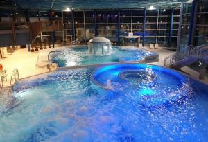 a large hot tub in a building with blue water at Palazzo Moni - Modernes Studio in der Nähe der Therme mit Balkon & Parkplatz in Bad Soden-Salmünster
