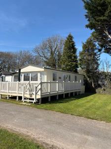 a mobile home with a porch and a fence at Rowan 42 in New Milton