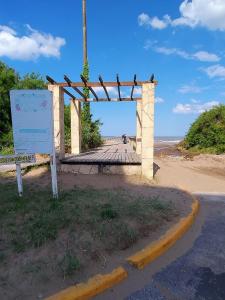 a wooden arch with a sign on the beach at Apartment 1 block from the sea in Mar de Ajó +2 photos