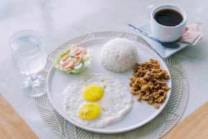 a plate with eggs and rice and a cup of coffee at Serenity Busay Room 8 in Cebu City